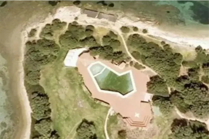 Aerial view of a strange star-shaped structure on Google Earth surrounded by trees and a beach shoreline.