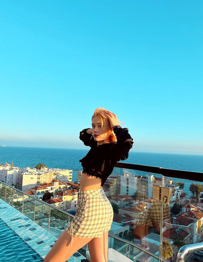 Model posing on a rooftop overlooking the sea, related to "Porta Potty" party trafficking investigation.