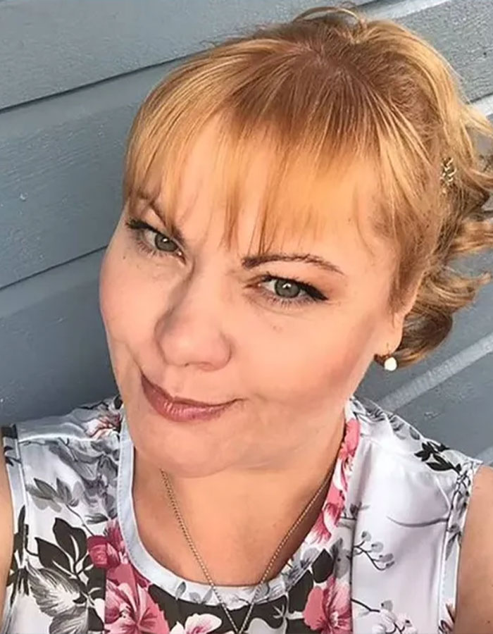 A woman with red hair in a floral top, relevant to model trafficking at parties investigation.