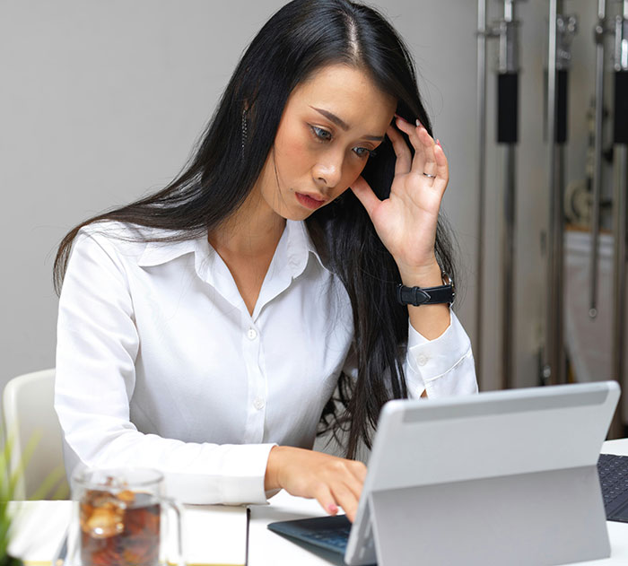 Frustrated woman in white shirt using a modern device, highlighting the inconvenience of technology.