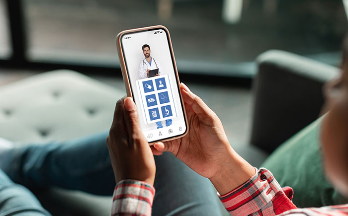 Person on a smartphone having a virtual doctor appointment, demonstrating modern conveniences.