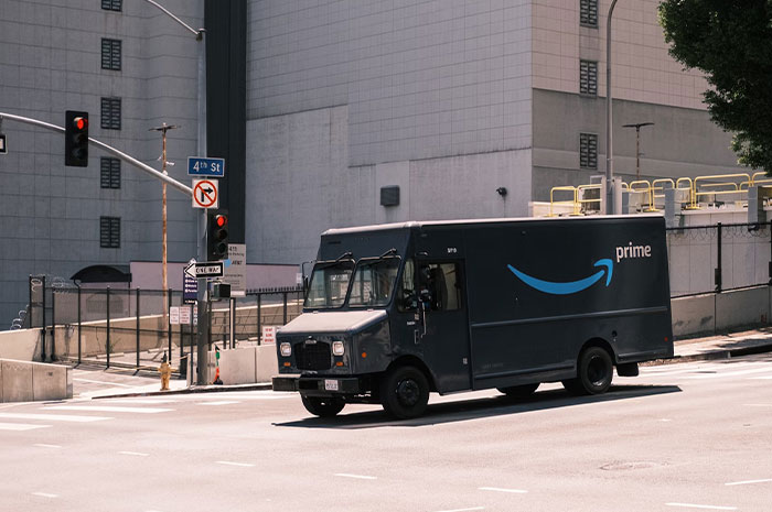 Amazon delivery truck on city street, highlighting industry ripoff realization theme.