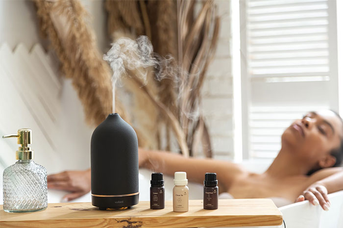 Aromatherapy scene with a diffuser and essential oils, questioning industry's value.