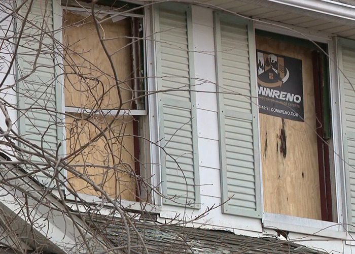 Boarded windows of a house where a stepson allegedly imprisoned for decades set fire to escape.