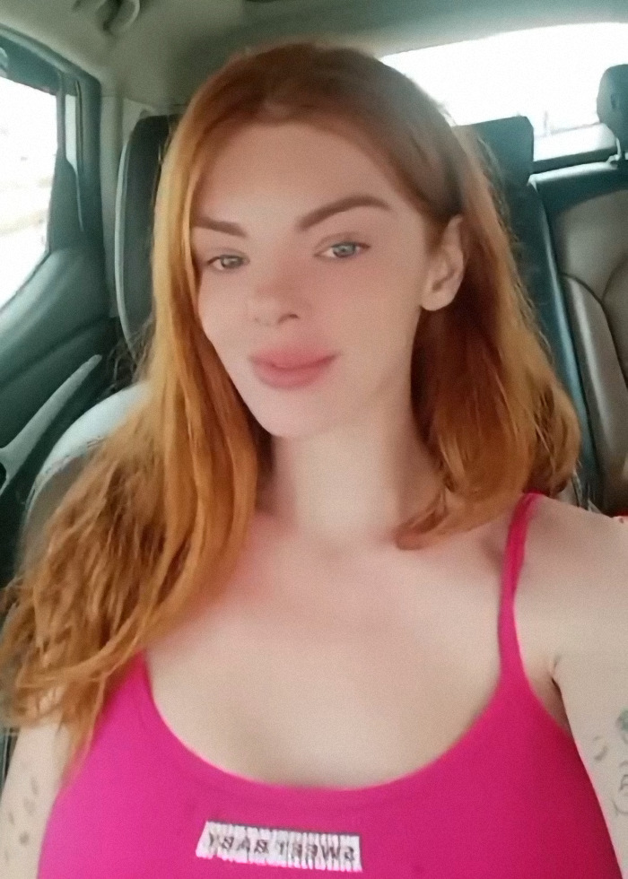 Red-haired woman in a car, related to viral "Mom on the Run" teaching UK expats about claiming benefits.