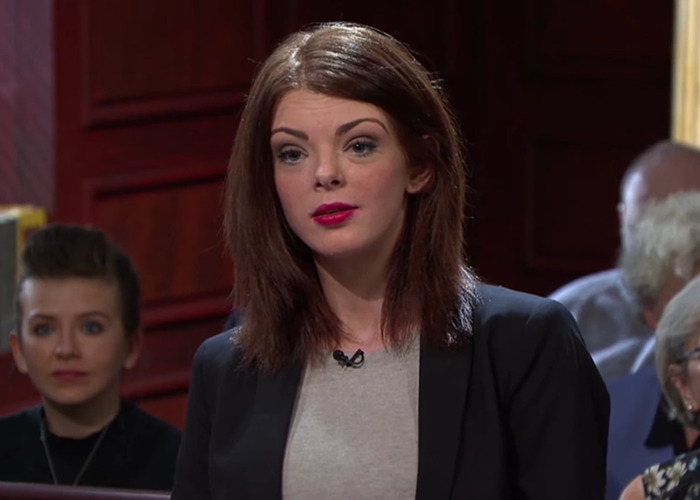 Woman speaking in a courtroom setting linked to UK expats and benefits advice.