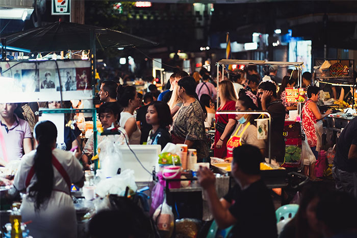 Crowded night market scene filled with people and colorful food stalls, capturing the essence of unforgettable coincidences.