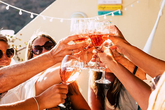 People toasting with glasses of rosé wine, symbolizing memorable coincidences.