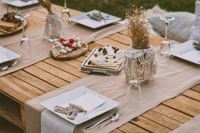 Rustic outdoor table setting with dried flowers and appetizers, related to bridesmaids' experiences at weddings.