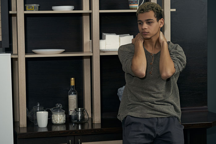 Young man looking stressed in kitchen, concerned about unexpected visit. Young man looking stressed in kitchen, concerned about unexpected visit.