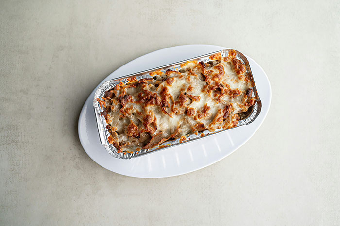 Homemade Indian food in a foil container on a white plate, gifted by a friendly neighbor.