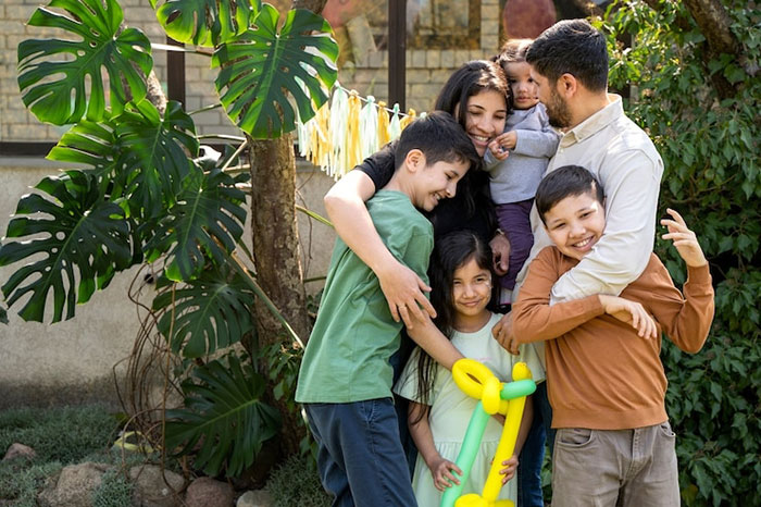 A family gathers outdoors with children holding a balloon, creating a warm, joyful atmosphere.