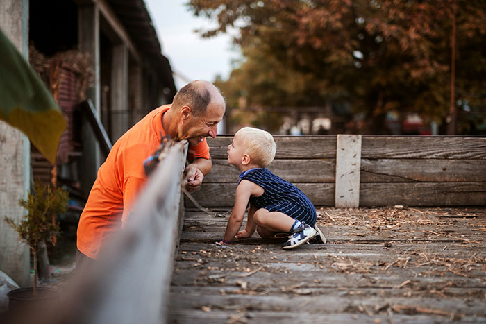 A father and toddler interact playfully outdoors, illustrating a parenting expert's insights on overcoming fears.