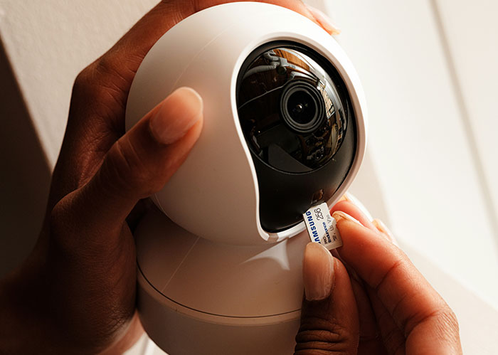 Hands adjusting a security camera lens, implying privacy concerns from an unhinged neighbor. Hands adjusting a security camera lens, implying privacy concerns from an unhinged neighbor.