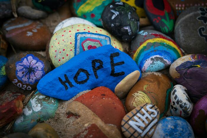 Colorful rocks painted with words and patterns, one prominently with "Hope," representing wild creativity and beliefs.