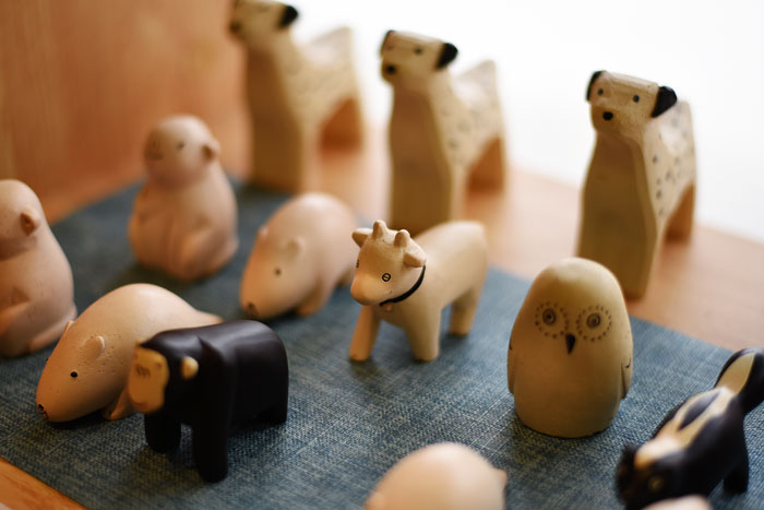 Wooden animal toys arranged on a surface, representing toys an aunt keeps until niece returns stolen trinkets.