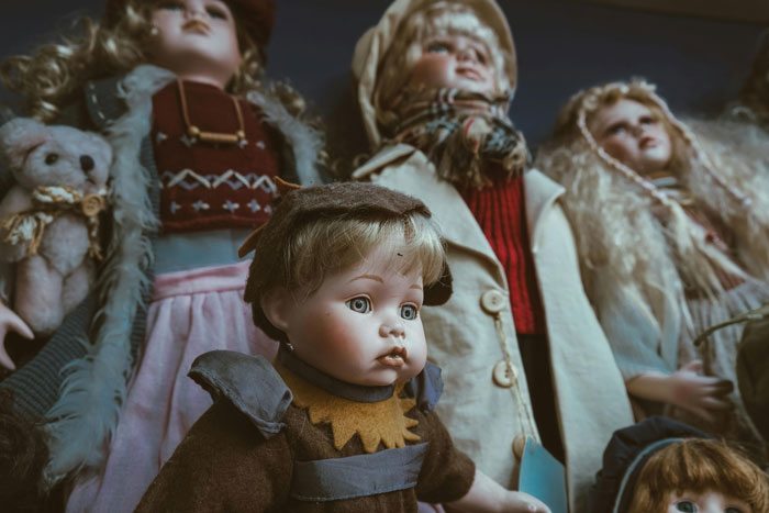 Heirloom dolls with vintage clothing displayed together, highlighting their intricate designs and nostalgic charm.