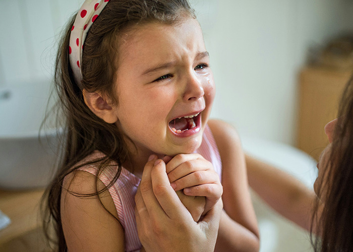 A child crying intensely, highlighting common childhood experiences that were actually traumatic.