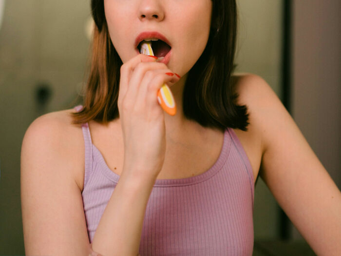 Person brushing teeth with a toothbrush, linked to unusual medical removals from bodies.