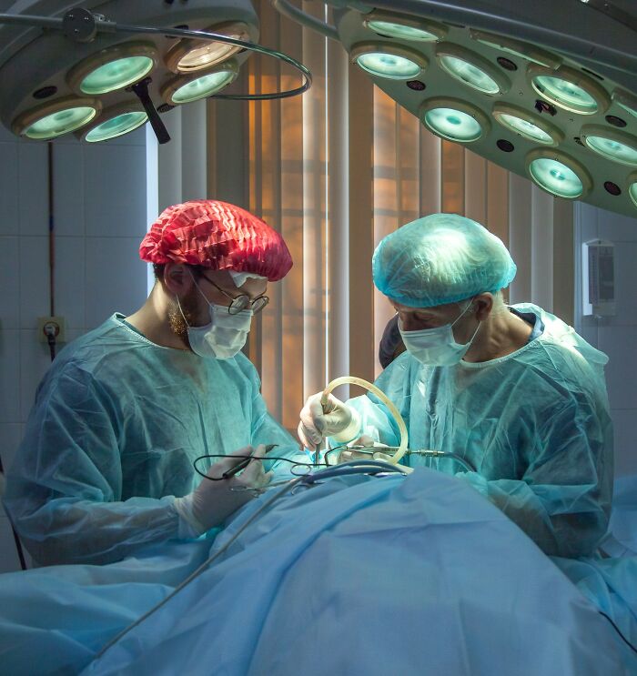 Doctors performing surgery to remove an unusual object from patient's body.