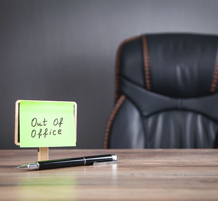 Out of office note beside a black chair, representing family-first vacation time.