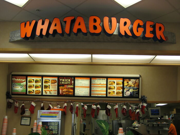 Whataburger counter with menu and festive decor, related to hyped fast foods.