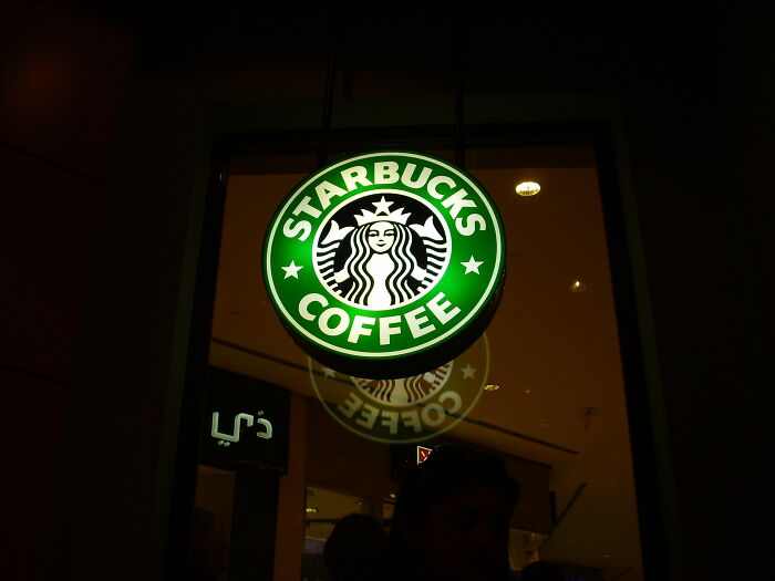 Starbucks Coffee sign illuminated at night, representing hyped fast foods that disappointed customers.