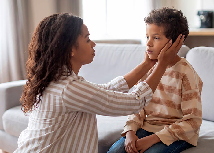 A parent gently holding a child's face, illustrating easier communication in parenting. A parent gently holding a child's face, illustrating easier communication in parenting.