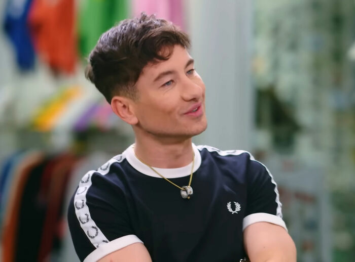 Young man in a casual outfit talking, highlighting diverse opinions on celebrity attractiveness.