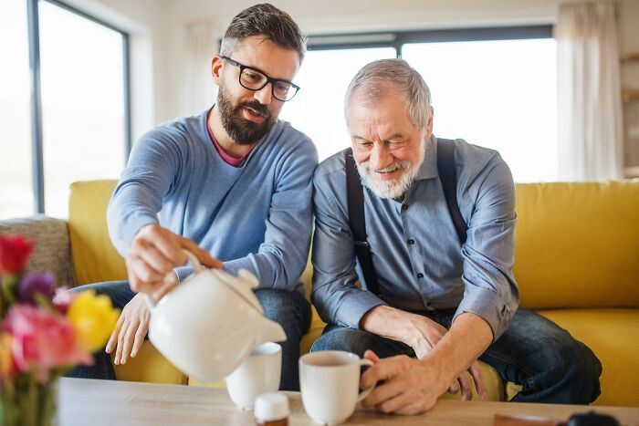 Two men sharing a moment over coffee in a cozy living room, reflecting on first-time home buyer experiences.