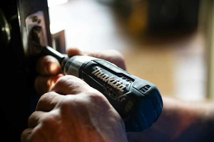 Hands using a power drill, illustrating a common task encountered by first-time home buyers.