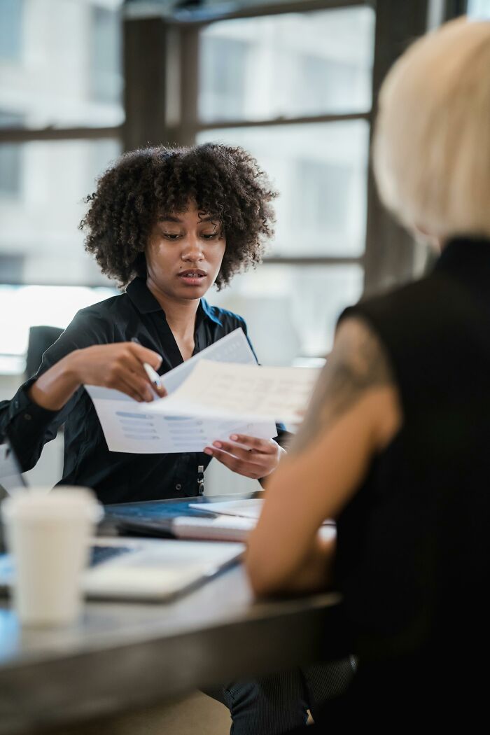 Person at a desk, focused on papers, possibly experiencing workplace frustration related to rage quitting a job.