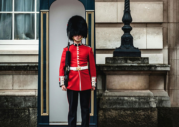 A British guard in uniform outside a building, part of a list where people share which country they make fun of.