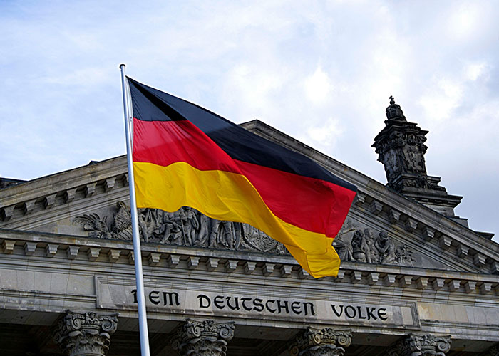 German flag waving in front of historic building, highlighting country in cultural context.