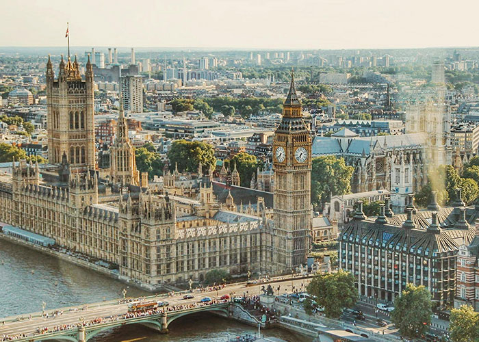 View of London's iconic landmarks, featuring the Houses of Parliament and Big Ben, representing a country often humorously critiqued.