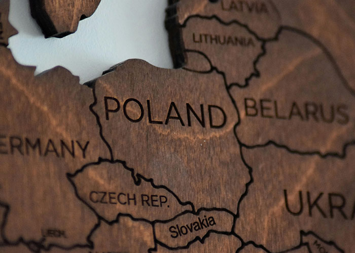 Wooden map highlighting Poland, surrounded by Germany, Belarus, and other countries.