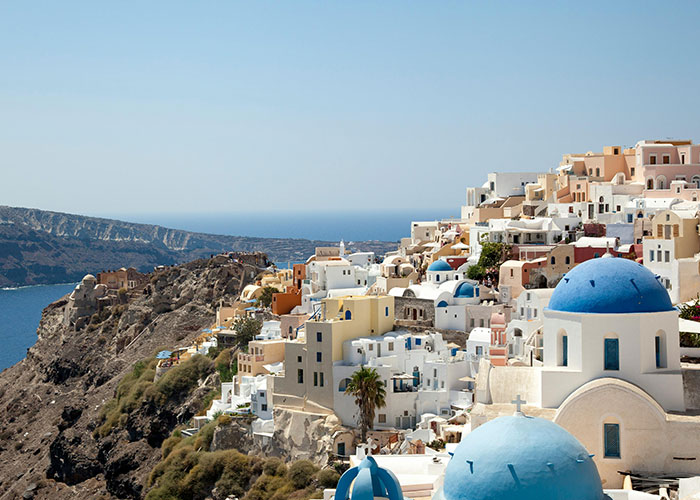 Greek island village overlooking the sea with white and blue buildings, main SEO keyword: country.
