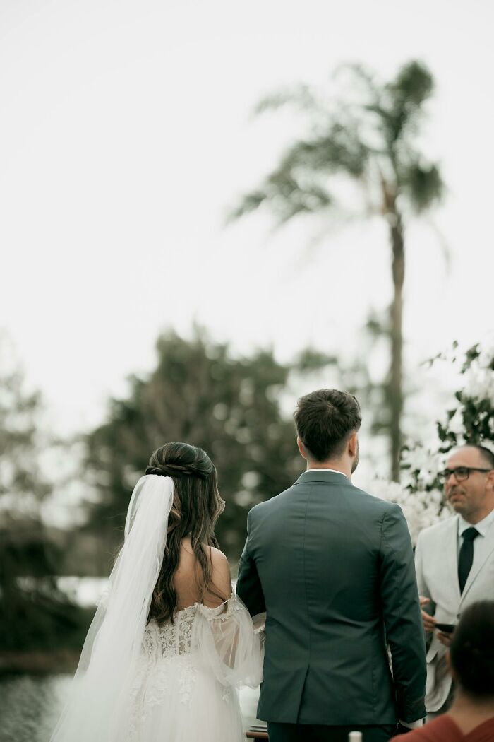 Bride and groom stand facing officiant outdoors, signaling potential wedding red flag moment.
