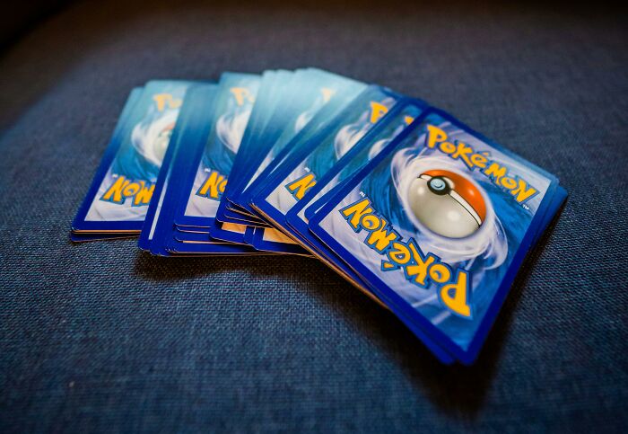 A stack of Pokémon cards on a blue surface.