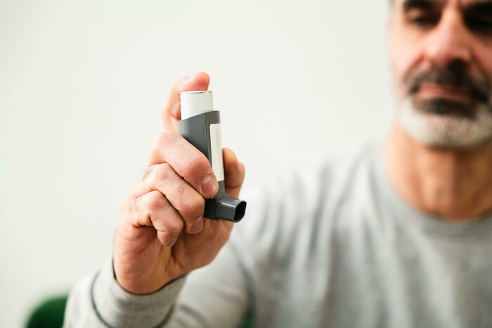 Person holding a nostalgic discontinued inhaler, focusing on its design.