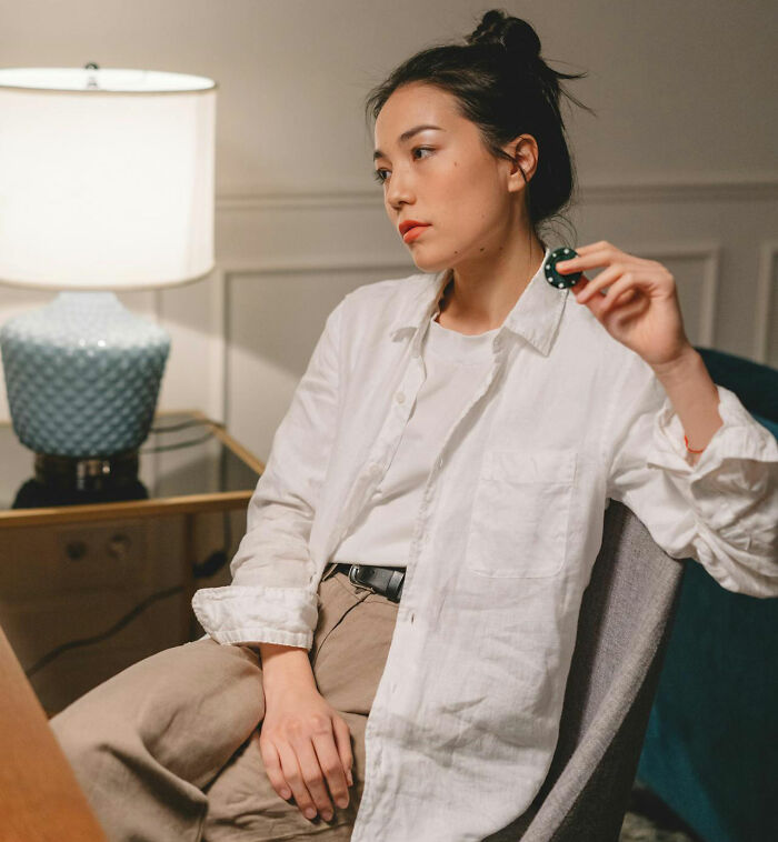 Person in a white shirt sitting pensively, related to worst job bonus experiences.