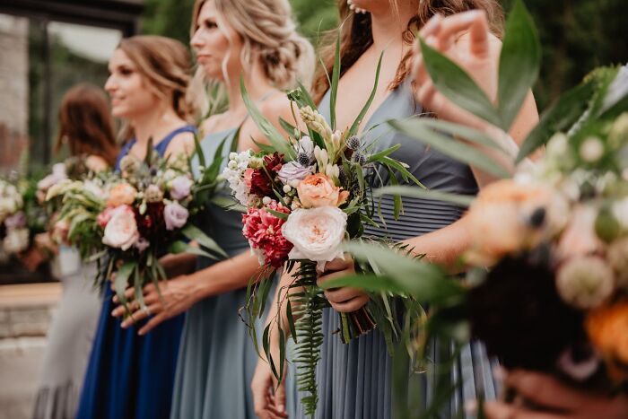 Bridesmaids in blue dresses holding floral bouquets at a wedding, highlighting potential red flags.