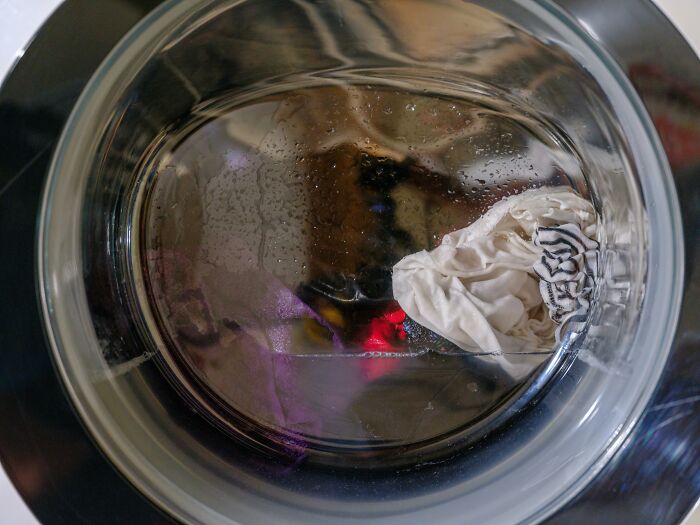 Inside view of a washing machine with a damp cloth, reflecting on frugal hacks like making bread at home.