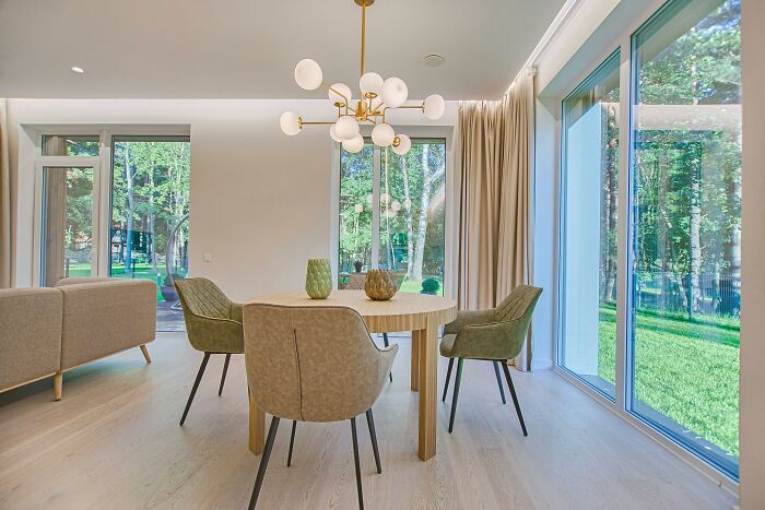 Dining area with minimalist decor and large windows in a middle-class home.