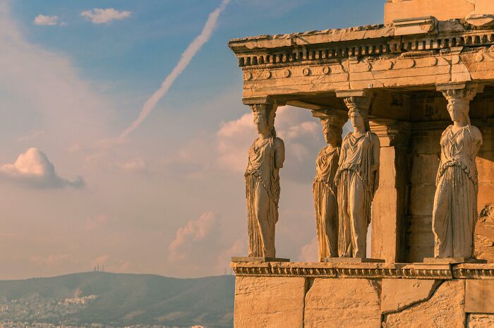 Ancient Greek architecture with caryatids under a vibrant sky capturing bizarre history.