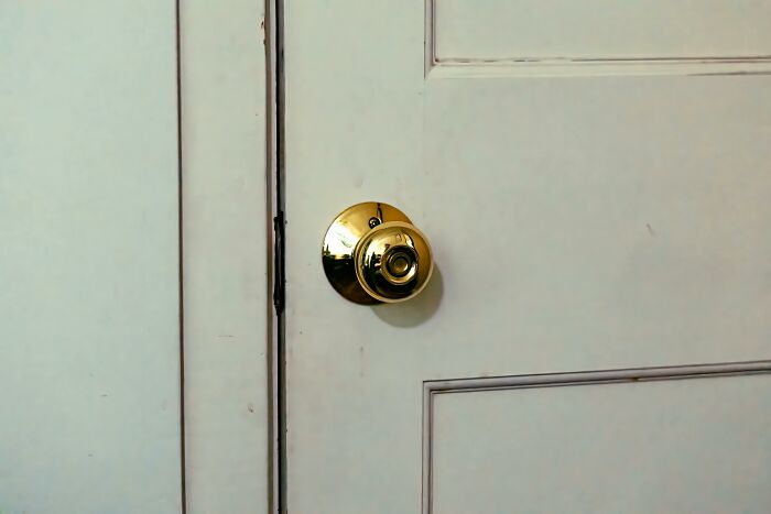 Gold doorknob on a painted white door, perfect for harmless April Fools’ pranks.