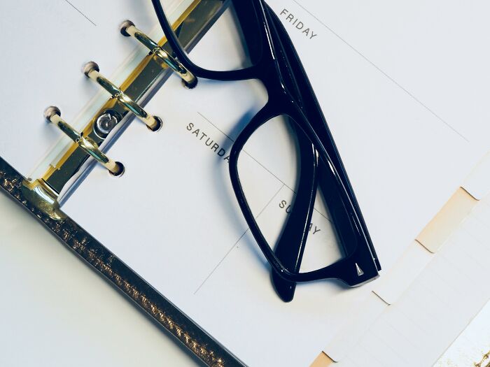 Glasses resting on a planner, symbolizing overused office expressions.