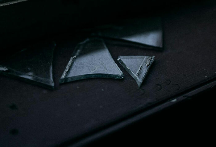 Fragments of glass on a dark surface, related to weirdest things removed from bodies.