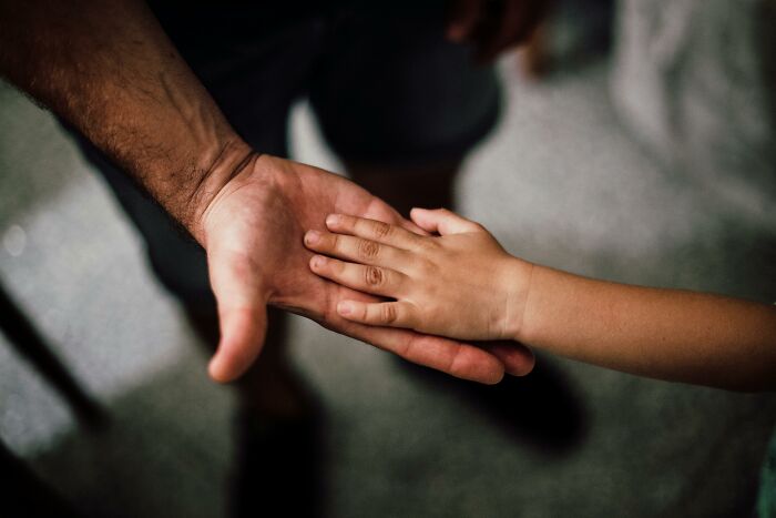 Child's hand resting in an adult's hand, symbolizing heartfelt connection and unforgettable compliments.