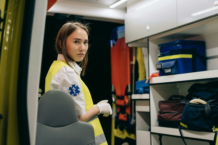 A paramedic in a yellow vest inside an ambulance, symbolizing unforgettable heartfelt compliments received at work.